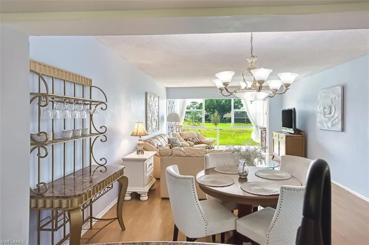 Dining space with light wood-style flooring, hanging lights, and a textured ceiling