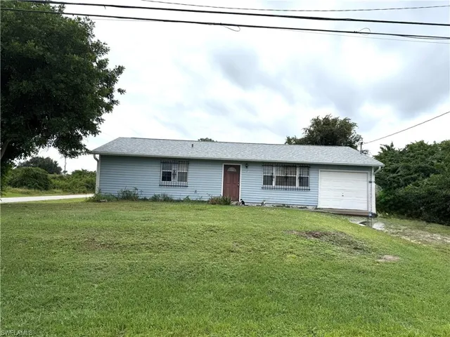 Ranch-style house featuring a front lawn and roof with shingles