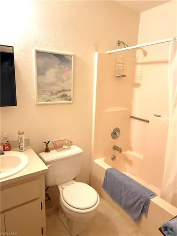 Full bath featuring shower / tub combo, vanity, and tile patterned flooring