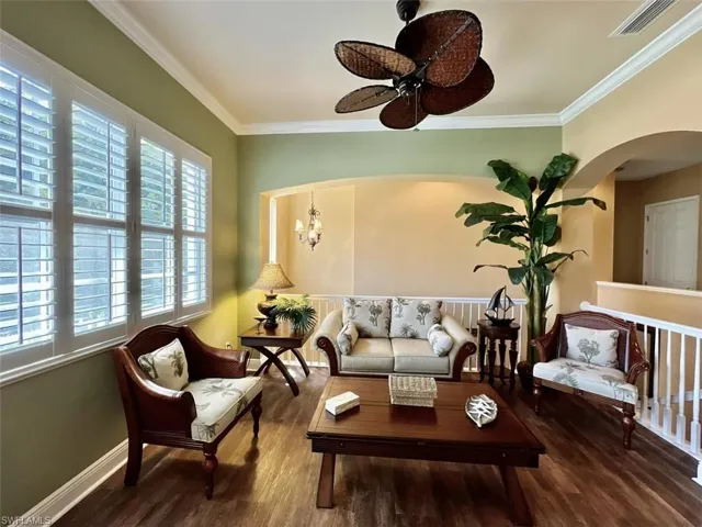 The open den provides a sitting room with ceiling fan and a wealth of natural light
