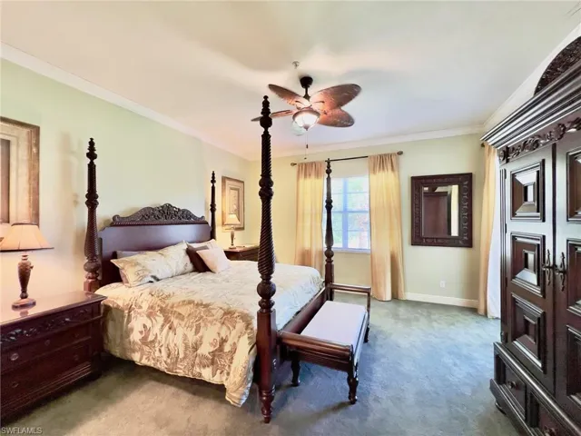 Spacious master bedroom with ceiling fan and crown molding