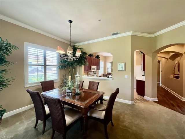 Dining room with a chandelier, and crown molding
