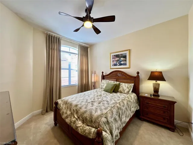 Guest carpeted bedroom with ceiling fan