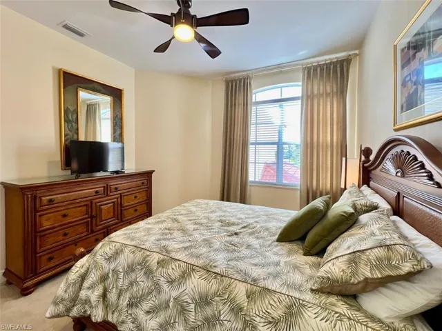 Carpeted bedroom featuring ceiling fan