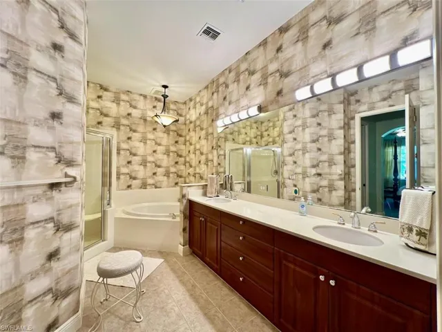 Bathroom featuring tile patterned flooring, vanity, and independent shower and bath
