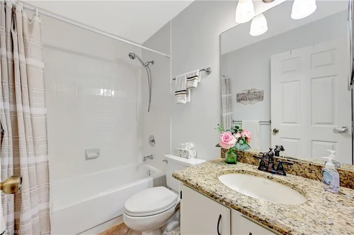 Full bathroom with shower / bath combo, vanity, and toilet