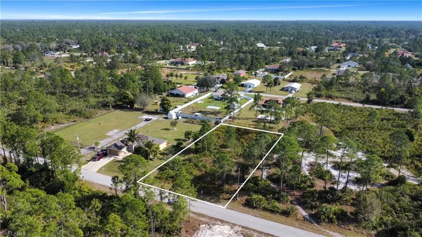 Aerial perspective of suburban area with a heavily wooded area and property parcel outlined