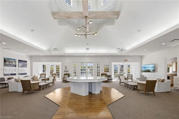 Living room with french doors, carpet floors, a chandelier, a high ceiling, and ornamental molding