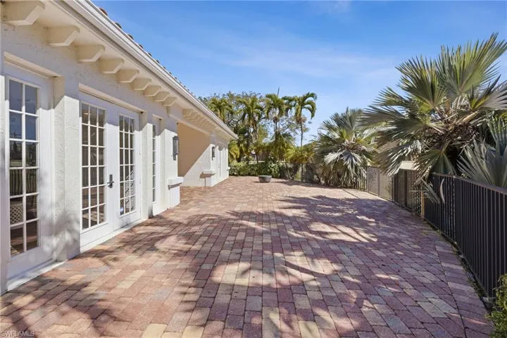 Fenced backyard with french doors and a patio