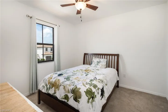 Bedroom with dark colored carpet and ceiling fan