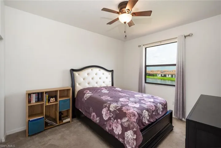 Carpeted bedroom featuring ceiling fan