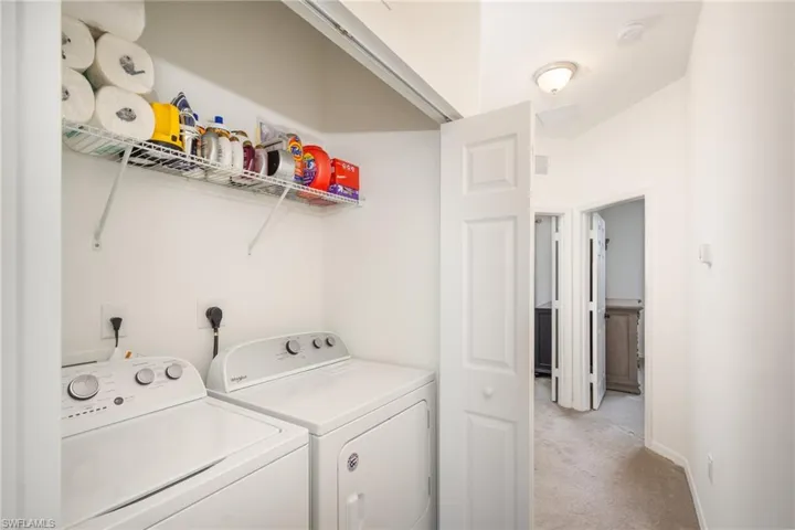 Laundry room with light carpet and independent washer and dryer