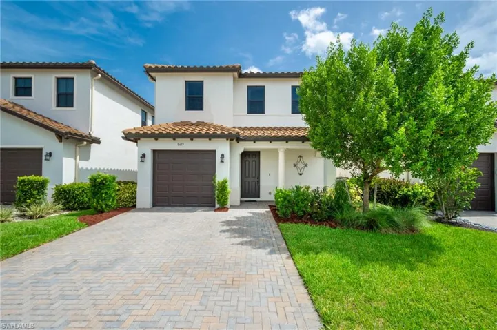 Mediterranean / spanish house with a garage and a front lawn