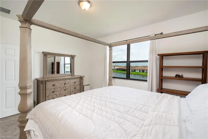 Owner's suite with carpet floors and a water view