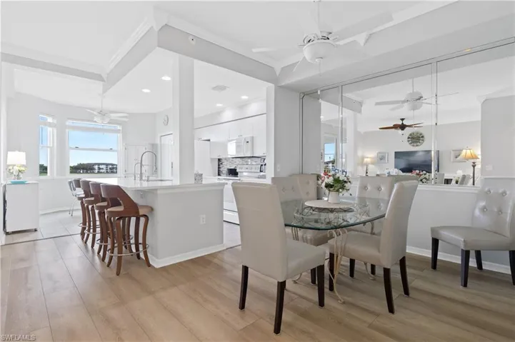 Dining room with ceiling fan, light wood finished floors, ornamental molding, and recessed lighting