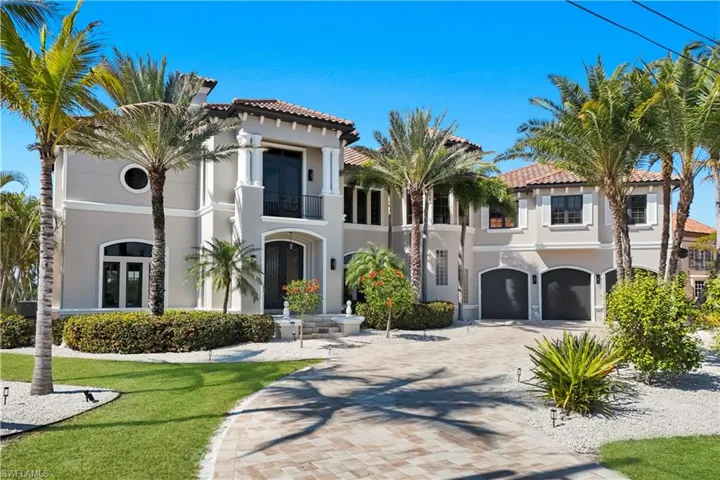 Mediterranean / spanish-style house with stucco siding, a tiled roof, a balcony, an attached garage, and driveway