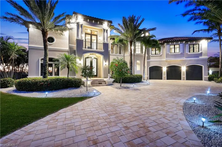 Mediterranean / spanish house featuring french doors, decorative driveway, an attached garage, stucco siding, and a balcony