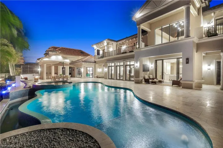 Relaxing pool / spa with a balcony, a patio area, outdoor furniture, and french doors