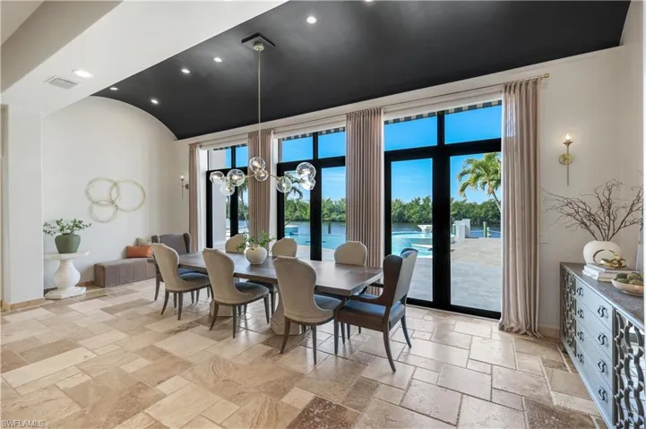 Dining room featuring a barrel ceiling, stone tile floors, and hanging lights