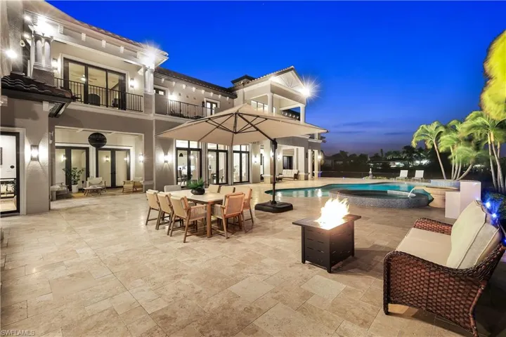 Patio / terrace with a patio area, a pool with connected hot tub, an outdoor fire pit, and outdoor dining area