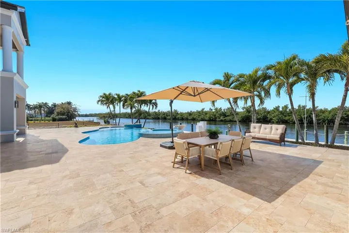 Combined pool / hot tub featuring a patio, outdoor lounge area, and a water view
