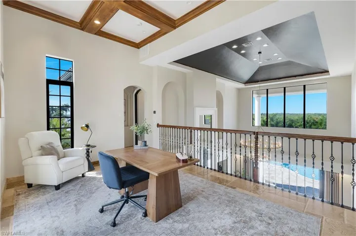 Office space featuring high coffered ceiling, recessed lighting, light tile patterned floors, and arched walkways
