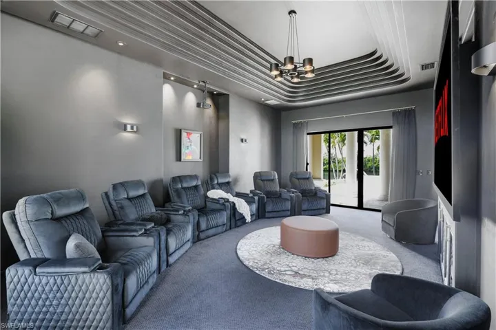 Carpeted home theater featuring suspended lighting