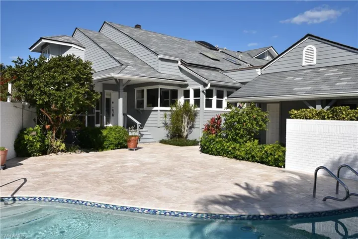 Sunny Oversized Pool Deck New Travertine Deck and Resurfaced Pool Towards Main Front Entry and to Covered Screened Porch and 3rd Bedroom Porch