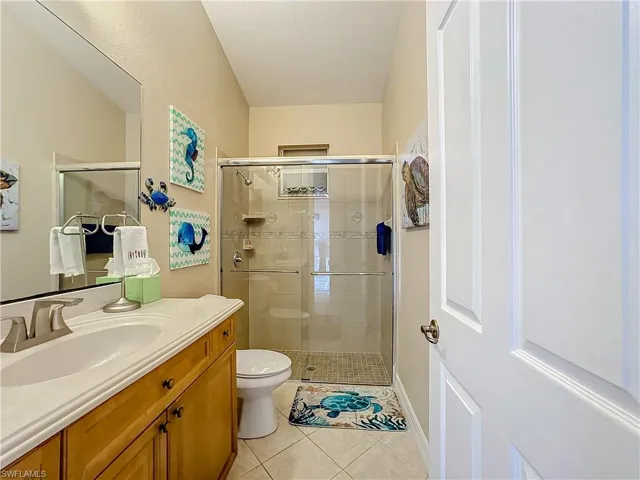 Full guest bath with vanity, a stall shower, and light tile patterned flooring