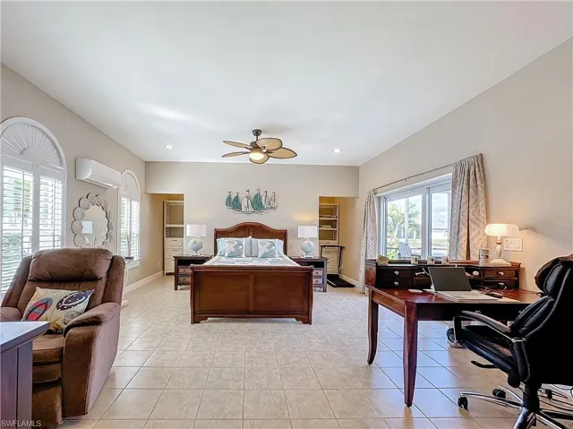 Bedroom with light tile patterned floors, a ceiling fan, an office area, and recessed lighting