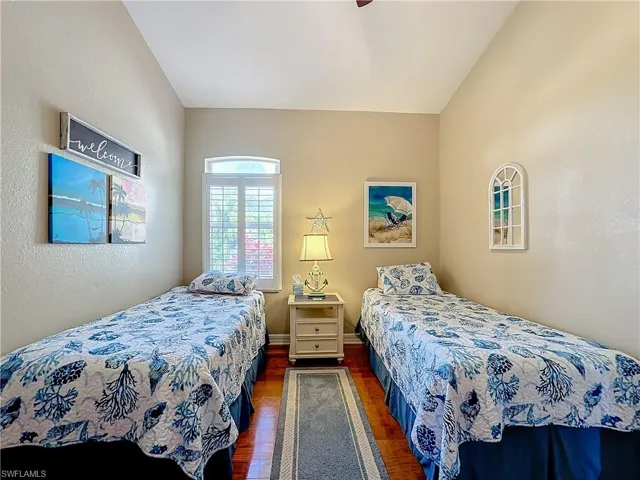 Bedroom featuring dark wood-style floors, a textured wall, and ceiling fan