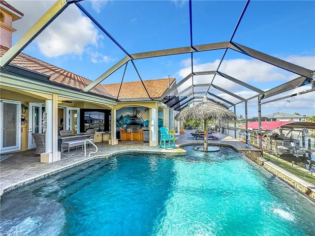 Outdoor pool with a lanai, a sunroom, a patio area, and an outdoor kitchen