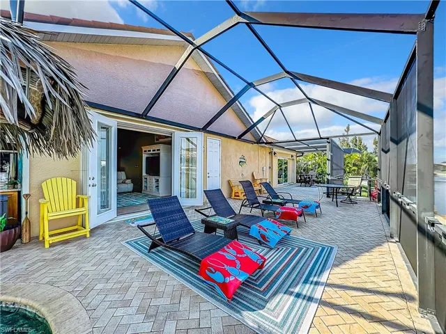 View of patio /sundeck, a lanai, outdoor dining space, and a swimming pool