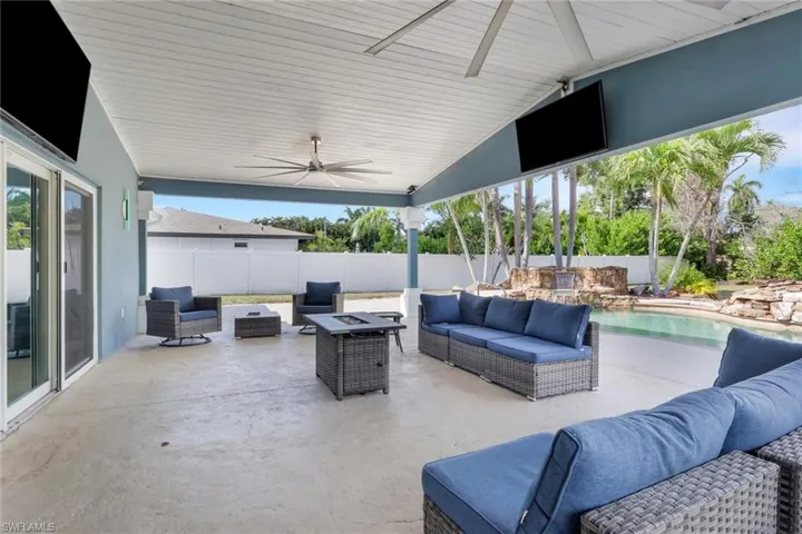 Fenced backyard with an outdoor living space with a fire pit, a patio, and a ceiling fan