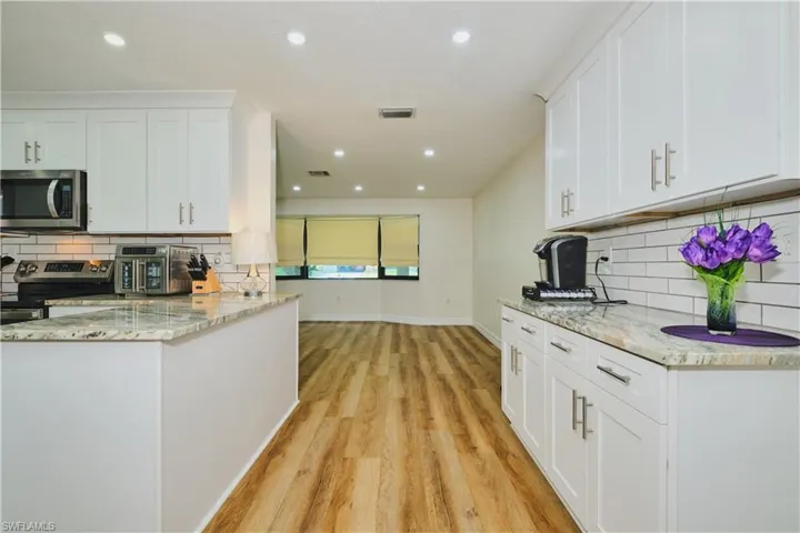 Coffee Bar with matching granite and backsplash and plenty of cabinets.