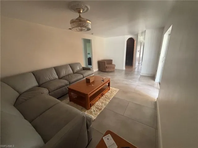 Back of property featuring a yard, a garage, a metal roof, and driveway