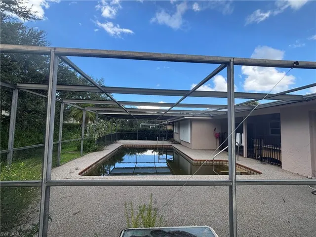 View of home's exterior with stucco siding, a garage, a gate, and a metal roof