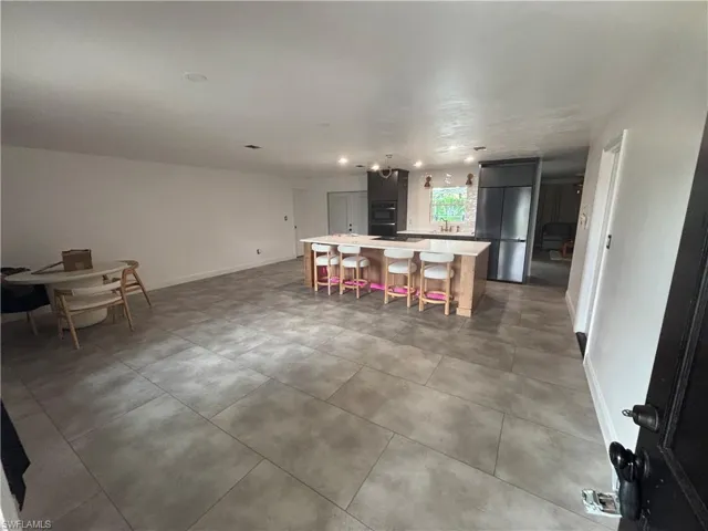 Bedroom featuring light tile patterned floors and baseboards