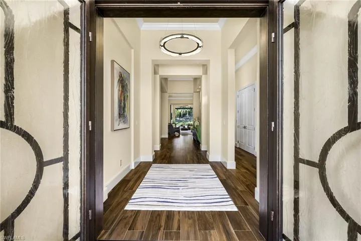 Corridor with dark hardwood / wood-style flooring and crown molding