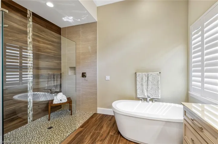 Bathroom featuring plus walk in shower and vanity