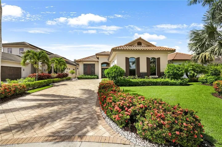 Mediterranean / spanish-style home with a garage and a front yard