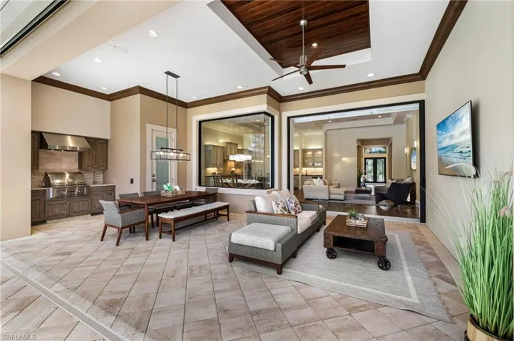 Living room with ornamental molding, light tile patterned floors, and ceiling fan