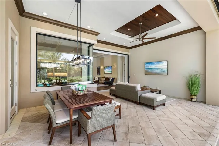 Tiled dining area featuring ceiling fan and ornamental molding