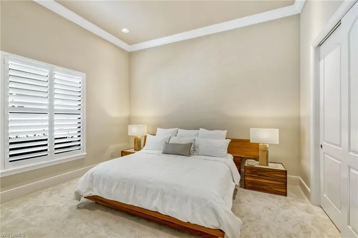 Bedroom featuring light carpet, a closet, and crown molding