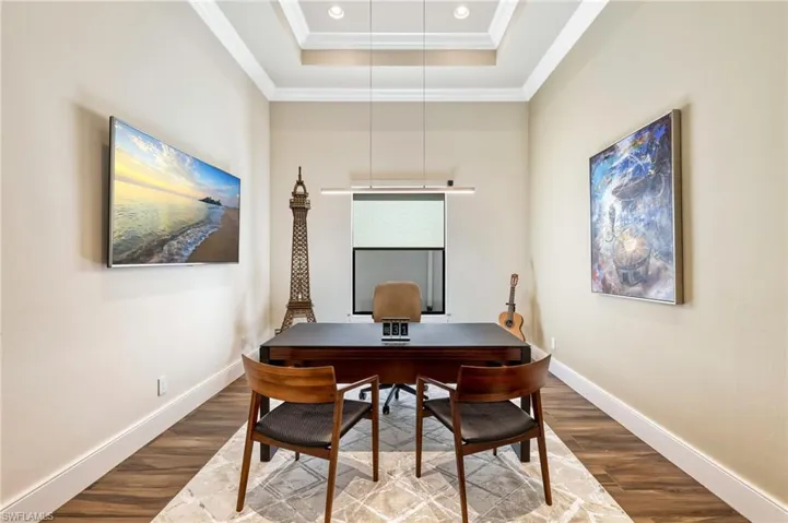 Office space with crown molding, a tray ceiling, and hardwood / wood-style flooring