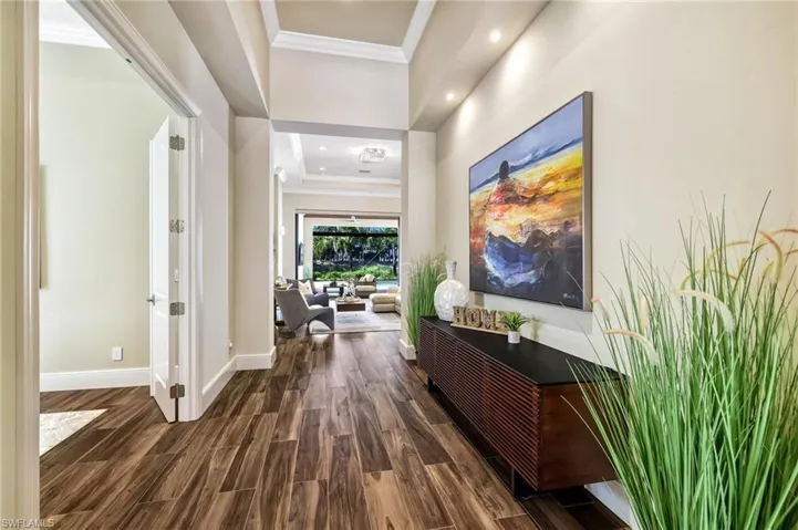 Corridor featuring dark wood-type flooring and crown molding