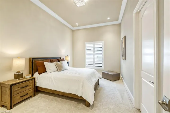 Carpeted bedroom featuring crown molding