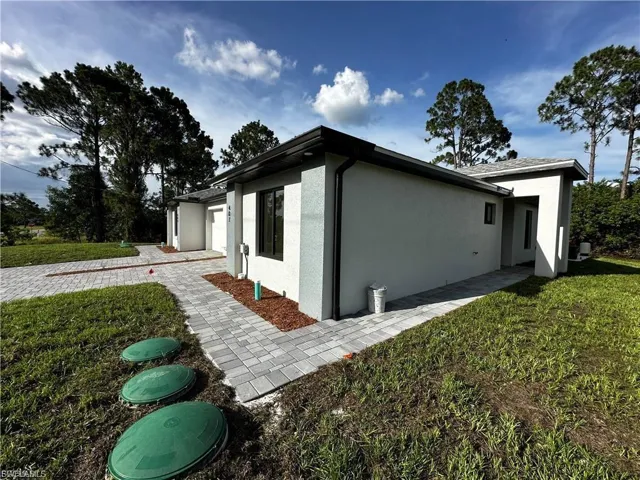 View of home's exterior featuring a lawn, stucco siding, and an attached garage