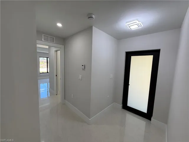 Hallway with baseboards and recessed lighting