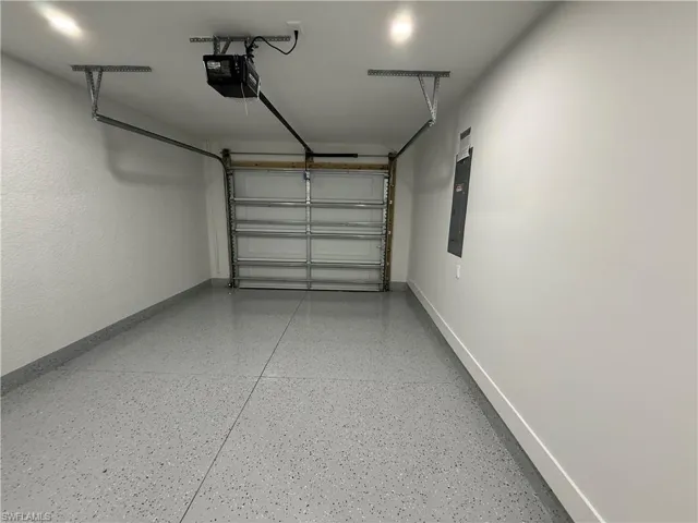 Garage featuring a garage door opener and electric panel